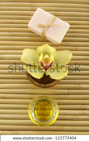 natural handmade soaps with orchid on bowl, massage oil on wooden board