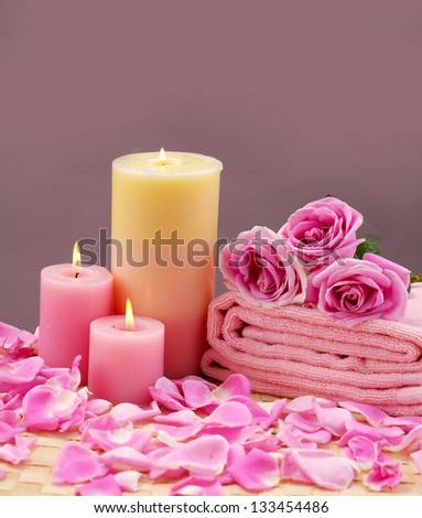 spa setting with candle ,rose flower ,towel on bamboo mat