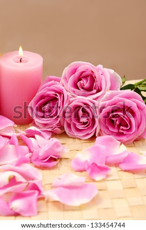 Pink spa sitting candle and rose flowers with petals