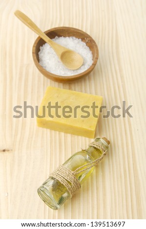 Salt on bowl ,soap , spoon, massage oil on a wooden board