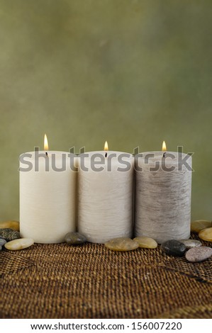 Three candle with stones on wicker mat
