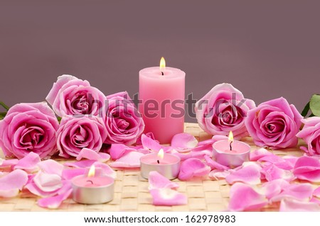 Pink spa sitting candle and rose flowers with petals