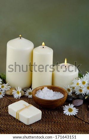 White candle with Zen rock and beautiful spring flower on mat