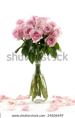 Bouquet of pink roses in glass vase with petals isolated on white