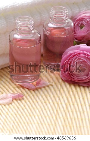 bottles of aromatic oil with pink gardenia, on mat