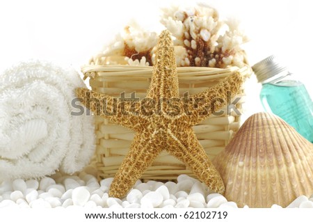 Spa essentials and skin care items with starfish and sea shells on white pebble