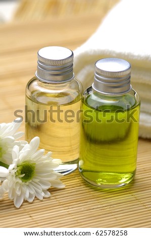Spa and beauty treatment -bottles with essential oils and towel on bamboo stick straw mat