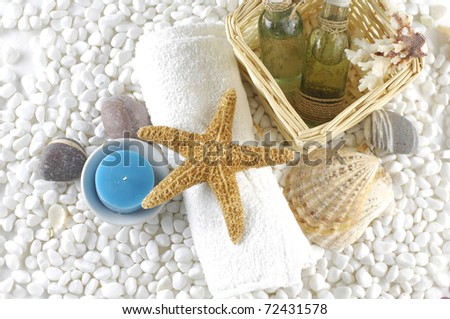Natural spa elements-spa essentials and skin care items on white pebbles