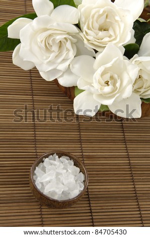 Branch gardenia and bath salt in bowl on bamboo napkin bamboo