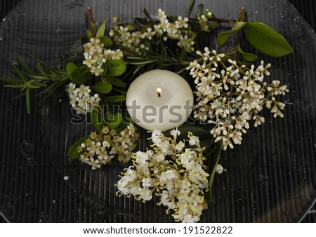Branch white flower and white candle on mat
