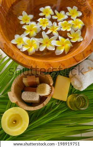 spa sitting with salt in spoon and roller white towel ,massage oil ,candle ,flower in bowl on palm texture