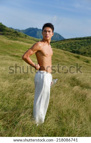 Yong muscular man in sport standing on mountain