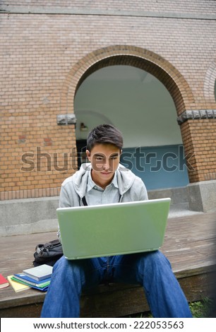 Portrait of Asian student sitting use laptop in her hand at campus