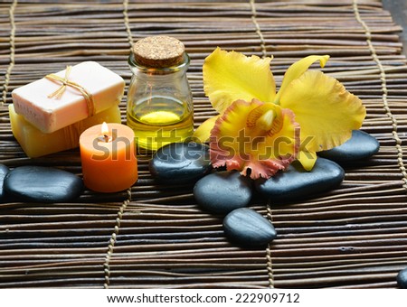 Zen rock and Handmade soap with candle, yellow orchid on mat