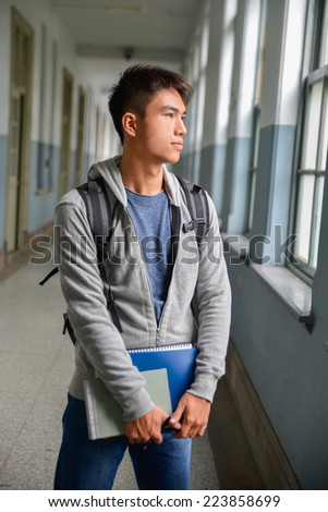 Portrait of college student holding book at college