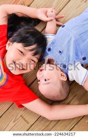 happy kids ,baby on the floor laying on wooden floor