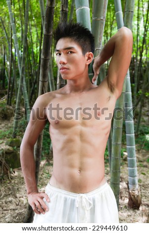 Healthy muscular young man doing sport at nature forest