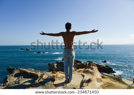 Full body man on beach doing yoga