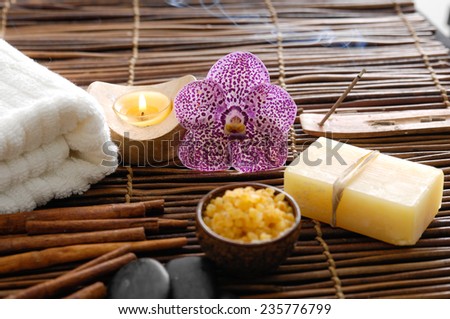 Spa treatment. Burning candle, spa stones, towel , orchid flowers