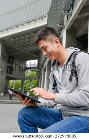 college student sitting at college using a tablet pc at campus