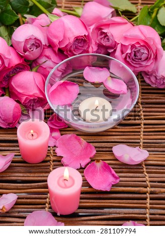 Three white Candles and rose with Petals on mat