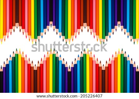 Multiple colored pencils isolated on white and arranged in a zigzag pattern.