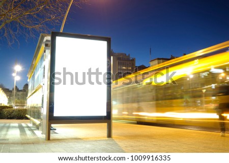 Blank advertisement mock up in a bus stop, with blurred traffic lights at night