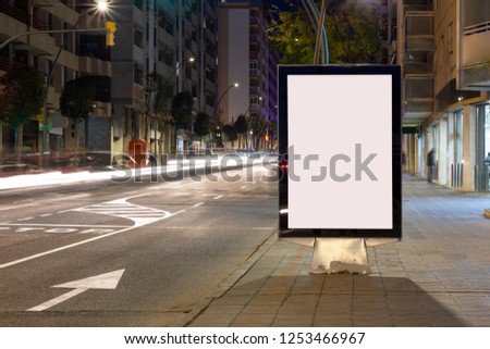 Blank advertisement billboard, with blurred traffic lights at night