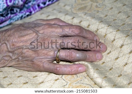 Old woman hand, on the sofa