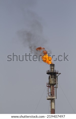 Fire from a gas torch, in a large oil refinery