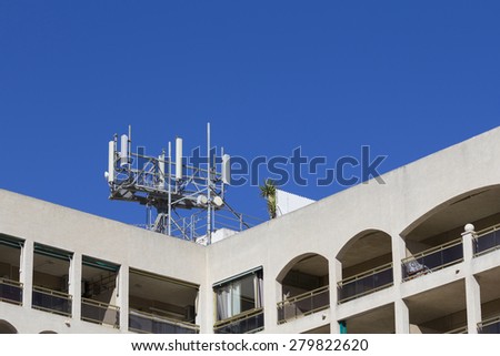 Mobile antenna in a building, against blue sky