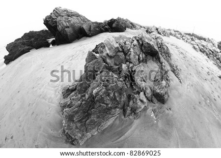 Rocks in beach sand (black and white photo)