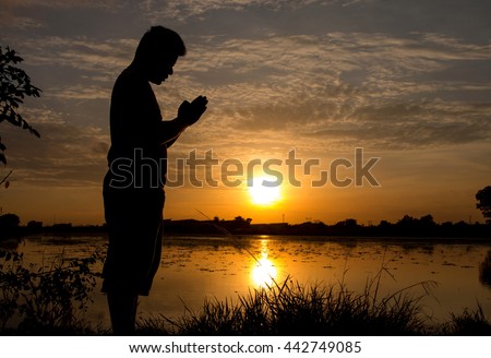 silhouette of man praying during sunset