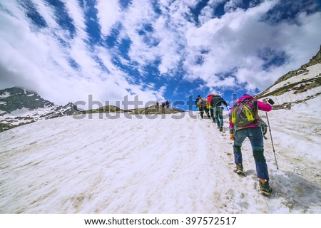 climbers climbing mountain with snow field