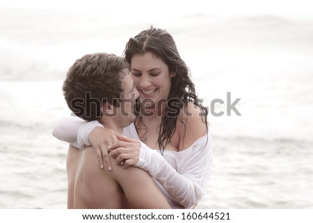 Young attractive couple sharing a happy moment at the beach