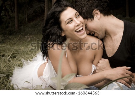 Young beautiful caucasian couple in forest sharing a happy moment