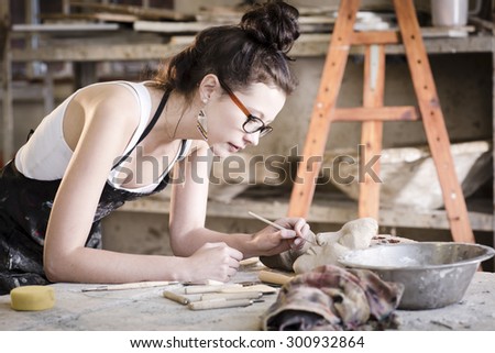 young artist moulding raw clay in art studio