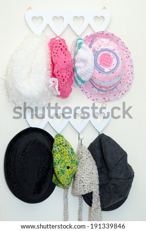 Selection of baby hats hanging on a rack with hearts