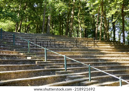 Small amphitheatre in the forest with sunlight on the steps
