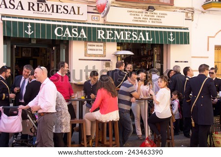 SEVILLE, SPAIN - 16 MARCH 2014: People relaxing and drinking on a terrace after the procession of Maria Auxiliadora in the district La Triana, Seville,  Spain.