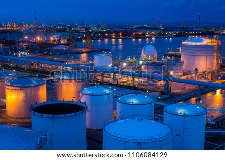Big Industrial estate  a lot of oil tanks in a refinery with treatment pond at industrial plants twilight time , copy space