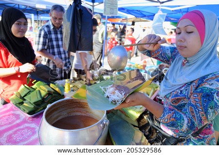 Tuaran, Sabah Malaysia - July 11, 2013. A  lady selling a traditional food locally known as \
