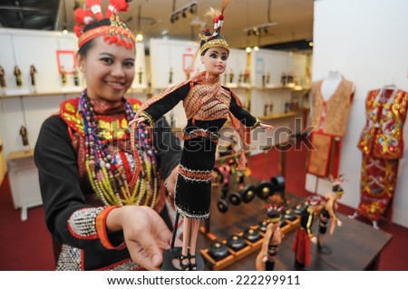 Tamparuli, Sabah Malaysia. August 26, 2014 : Lady in Dusun Lotud costume showing doll wearing Dusun Lotud costume too at  Chanteek Borneo Gallery at Tamparuli Sabah Malaysia.