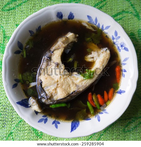 Selective focus of native Borneo fresh water fish spicy herbal soup with home stay table setup.