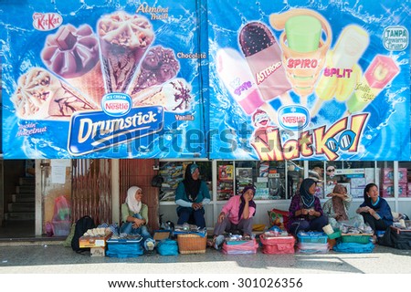 Ranau Sabah Malaysia - August 23, 2013:A group of unidentified streets vendor selling items under the shade made from advertisement banner of international ice cream company at Ranau streets.
