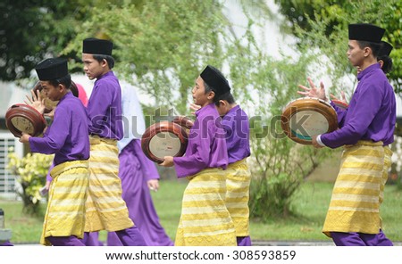 Kota Kinabalu Sabah Malaysia-December 27, 2014:Male performers dressed in Malay traditional costume playing instrument called Kompang during traditional wedding parade in Kota Kinabalu Sabah.