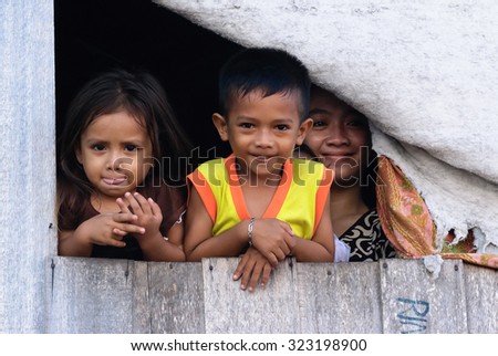 Mabul Semporna Sabah - June 5, 2011:Unidentified members of a small family in Mabul Island give a warm smile for the camera.Mabul Island is well known as host for divers and tourist to Sipadan Island.