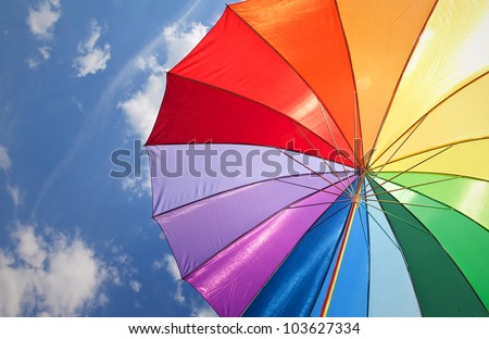 Rainbow umbrella on sky background