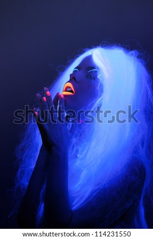 Uv light portrait, attractive woman with hands folded in prayer