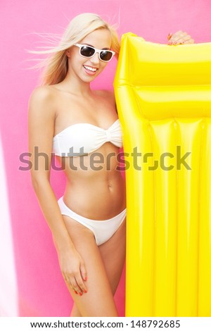 Beautiful young bikini girl with inflatable bed
